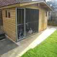 Load image into Gallery viewer, A scenic shot of the Elworth 10x4 dog kennel set in a garden, illustrating its suitability as a year-round outdoor shelter.