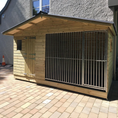 Load image into Gallery viewer, wooden dog kennel from the front, highlighting the apex roof and entry points for the run and sleeping area.