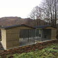 Load image into Gallery viewer, A multi-unit wooden dog kennel block with multiple runs. The structure is built with pressure-treated timber and features galvanized steel bar panels for the runs, with each unit having a separate, enclosed sleeping area. The kennel is designed for multiple dogs and is durable and secure.