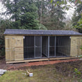Load image into Gallery viewer, KENNELSTORE Wymbury Double Wooden Dog Kennel, a 21ft x 5ft multi-dog housing unit. The kennel features a distinctive apex roof and is made from pressure-treated tanalised timber, with two separate runs equipped with galvanised panels for security.