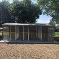 Load image into Gallery viewer, A multi-unit wooden dog kennel block with multiple runs. The structure is built with pressure-treated timber and features galvanized steel bar panels for the runs, with each unit having a separate, enclosed sleeping area. The kennel is designed for multiple dogs and is durable and secure.
