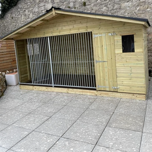 A Kennelstore 14x6 Elworth Apex Wooden Dog Kennel & Run. The pressure-treated outdoor shelter features a classic apex roof design and a secure galvanized steel run panel.