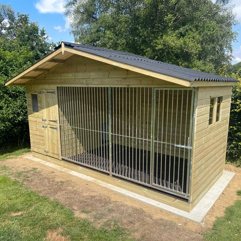 A Kennelstore 14x6 Elworth Apex Wooden Dog Kennel & Run. The pressure-treated outdoor shelter features a classic apex roof design and a secure galvanized steel run panel.