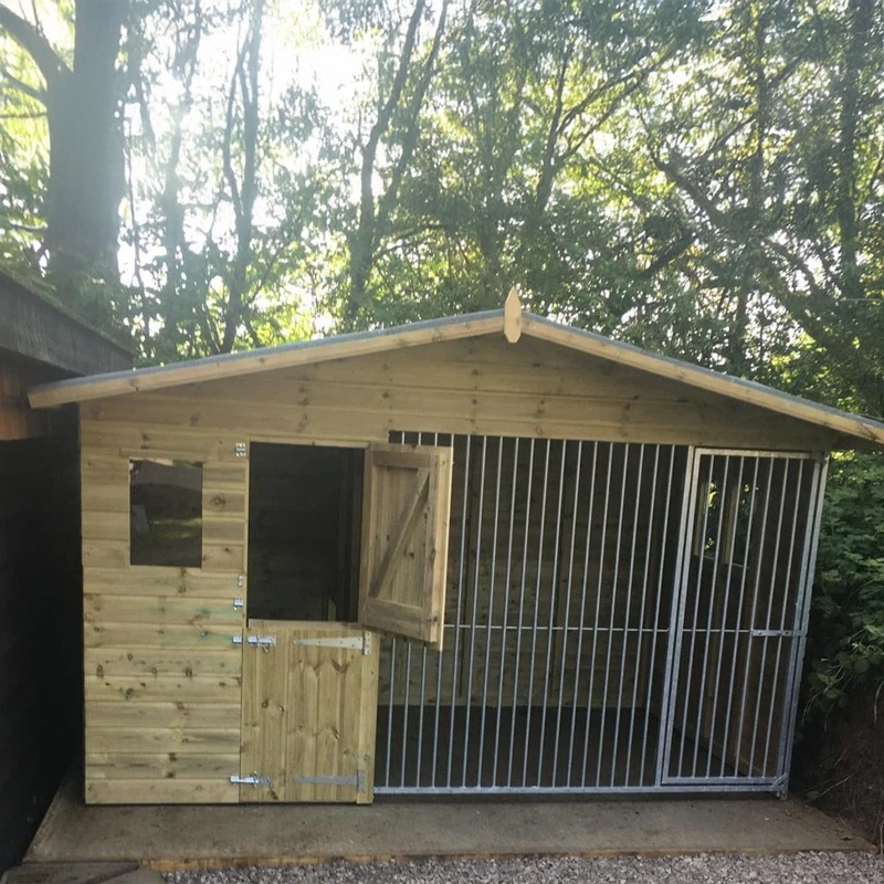 A Kennelstore 10x4 Elworth Apex Wooden Dog Kennel & Run. The pressure-treated outdoor shelter features a classic apex roof design and a secure galvanized steel run panel.