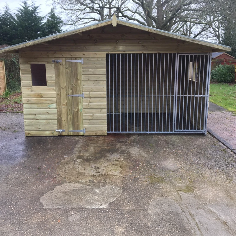 A Kennelstore 12x5  Elworth Apex Wooden Dog Kennel & Run. The pressure-treated outdoor shelter features a classic apex roof design and a secure galvanized steel run panel.