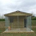 Load image into Gallery viewer, Large metal dog kennel with wooden roof on a grassy field
