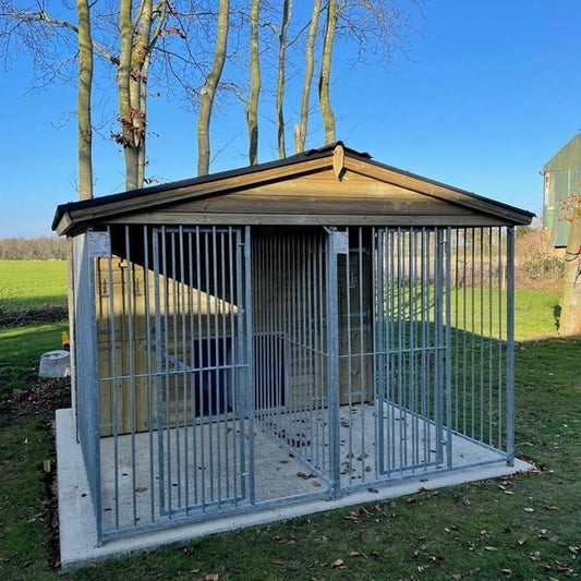 A large, 6x9 wooden Kennelstore Wymbury Double Dog Kennel and Run, featuring a classic apex roof. The kennel is constructed with durable, pressure-treated tanalised timber and includes galvanised steel panels, making it ideal for housing and separating multiple dogs securely.