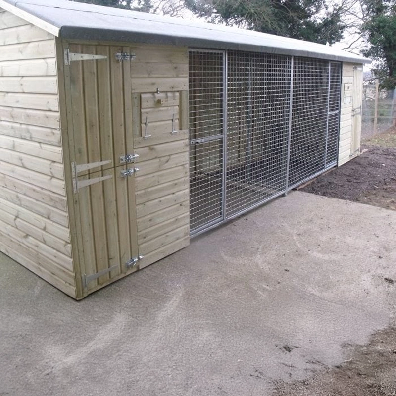 KENNELSTORE Wymbury Double Wooden Dog Kennel, a 21ft x 5ft multi-dog housing unit. The kennel features a distinctive apex roof and is made from pressure-treated tanalised timber, with two separate runs equipped with galvanised panels for security.